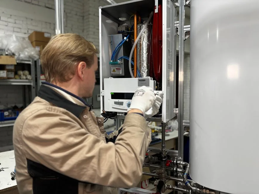 Technicien installant un équipement de chauffage, étape après l'achat en ligne d'un chauffe-eau thermodynamique