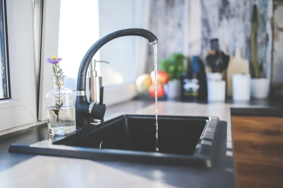 Robinet d'eau chaude dans une cuisine moderne, alimenté par un cumulus électrique ou un chauffe-eau thermodynamique